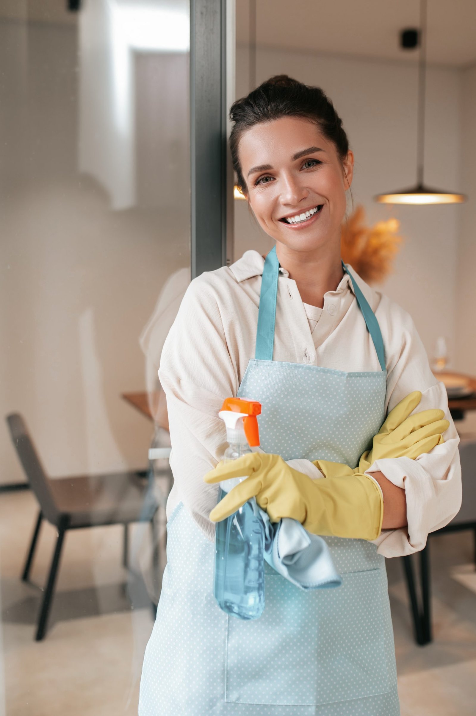 About Us 1 smiling housewife in apron standing in the kitchen
